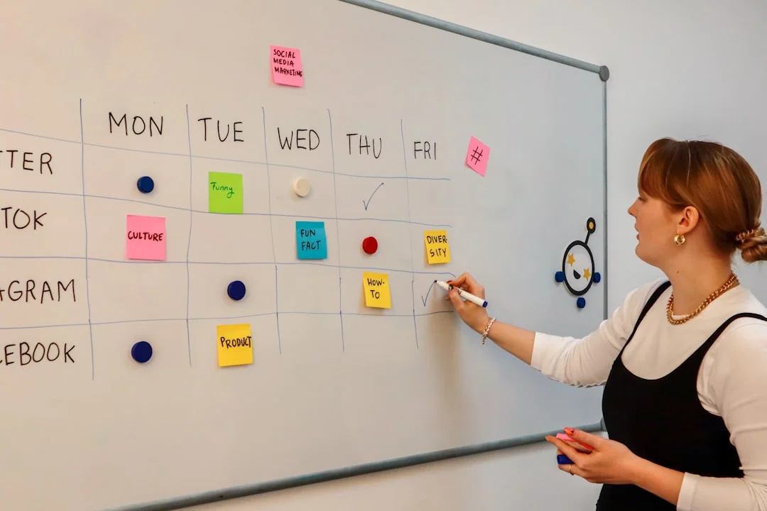 Individual using a smartphone to analyze the stock market from a home office.