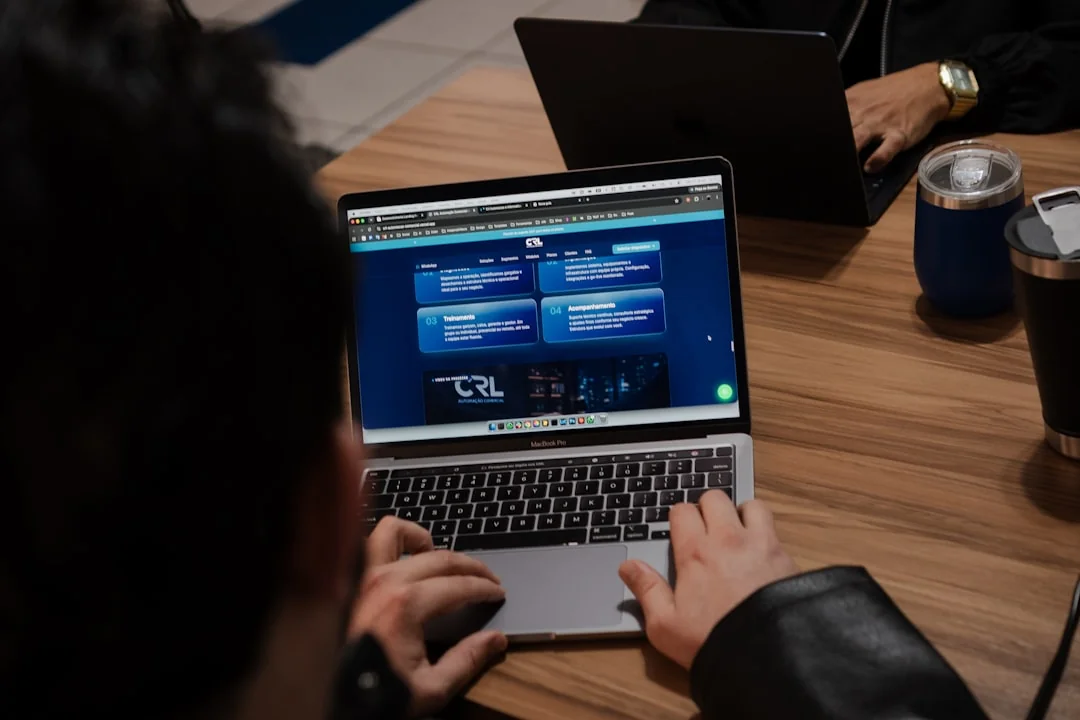 Hands typing on a laptop with cryptocurrency charts and smartphone display in view, focusing on digital finance.